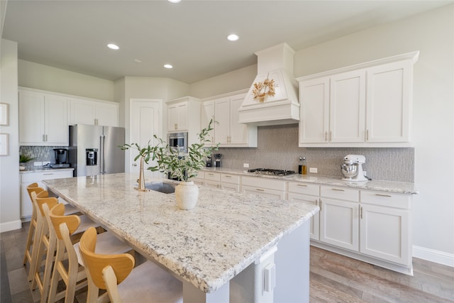 1253 Gray Fox Ln, Frisco, TX 75033 - kitchen featuring stainless steel appliances, premium range hood, white cabinets, decorative backsplash, and recessed lighting