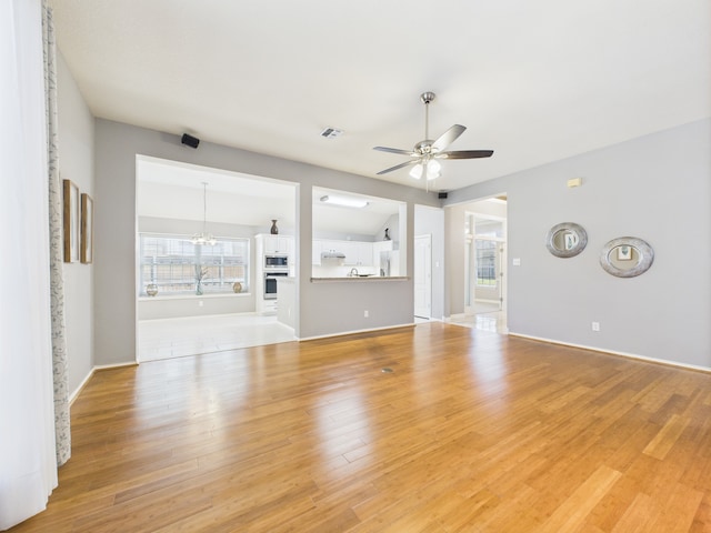 1197 Pleasant Oaks Dr, Lewisville, TX 75067 - unfurnished living room with ceiling fan, light wood finished floors, and a chandelier