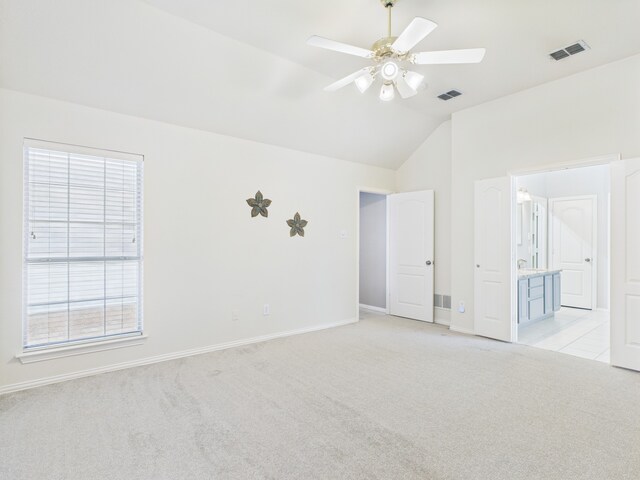 1197 Pleasant Oaks Dr, Lewisville, TX 75067 - unfurnished bedroom featuring light colored carpet, vaulted ceiling, ensuite bathroom, and ceiling fan