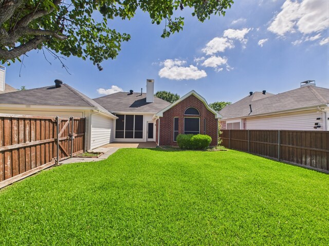 1197 Pleasant Oaks Dr, Lewisville, TX 75067 - back of house featuring a fenced backyard, brick siding, a chimney, and a gate