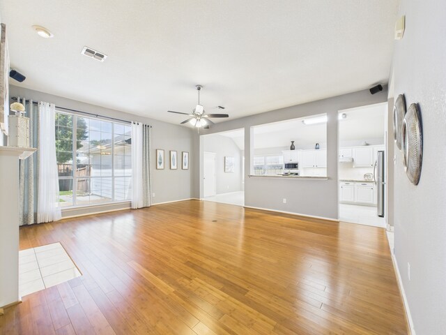 1197 Pleasant Oaks Dr, Lewisville, TX 75067 - unfurnished living room with ceiling fan and light wood finished floors