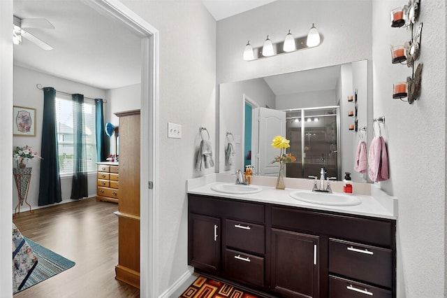 1712 Intervale Rd, Providence Village, TX 76227 - full bath with double vanity, a stall shower, wood finished floors, and ceiling fan