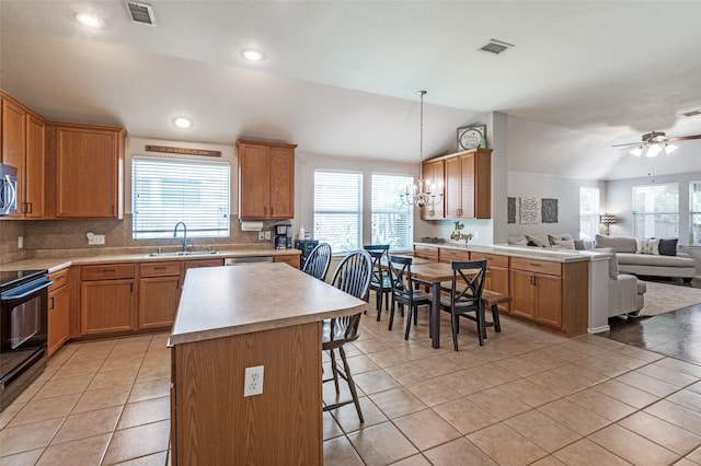 109 Niagara Falls Dr, Anna, TX 75409 - kitchen with stainless steel appliances, open floor plan, a breakfast bar, a chandelier, and vaulted ceiling