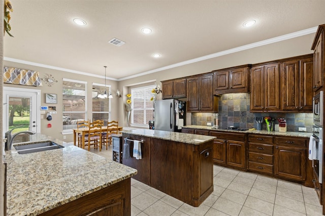 5024 Running Brook Dr, Joshua, TX 76058 - kitchen featuring stainless steel appliances, a center island, backsplash, decorative light fixtures, and ornamental molding