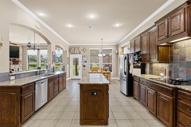 5024 Running Brook Dr, Joshua, TX 76058 - kitchen featuring stainless steel appliances, a kitchen island, decorative backsplash, a chandelier, and decorative light fixtures