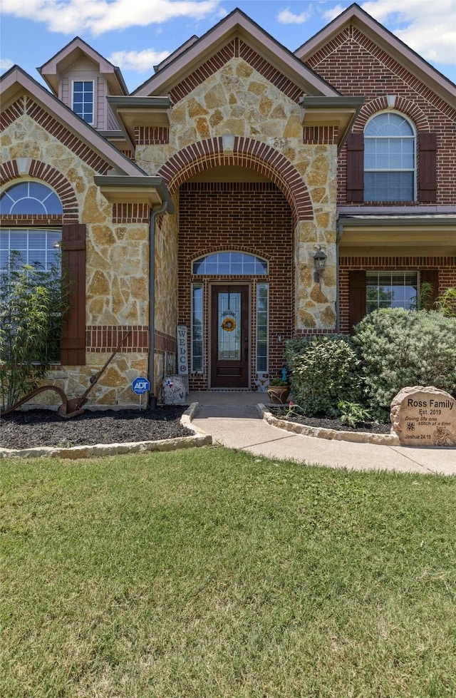 5024 Running Brook Dr, Joshua, TX 76058 - doorway to property featuring stone siding, a yard, and brick siding