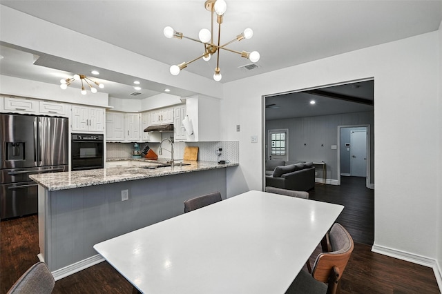 826 E Cherry St, Duncanville, TX 75116 - kitchen with stainless steel refrigerator with ice dispenser, a chandelier, a peninsula, white cabinetry, and under cabinet range hood