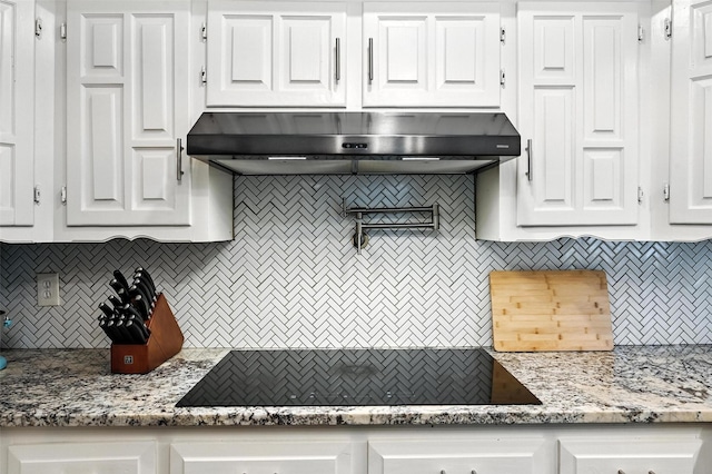 826 E Cherry St, Duncanville, TX 75116 - kitchen featuring under cabinet range hood, backsplash, and white cabinets
