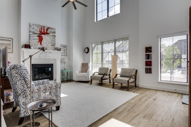 2128 Eastleigh Dr, Fort Worth, TX 76008 - living room featuring a high ceiling, healthy amount of natural light, a ceiling fan, wood finished floors, and a glass covered fireplace