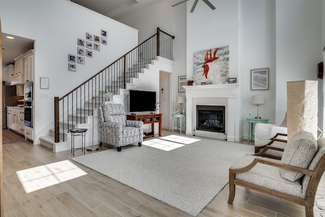 2128 Eastleigh Dr, Fort Worth, TX 76008 - living area with a high ceiling, stairway, light wood-style floors, and a glass covered fireplace