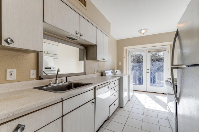 7814 Meadow Park Dr Unit 219, Dallas, TX 75230 - kitchen featuring freestanding refrigerator, dishwasher, washing machine and dryer, french doors, and light tile patterned floors