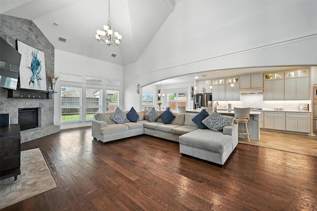 9840 El Colina Dr, Fort Worth, TX 76179 - living area with a chandelier, high vaulted ceiling, hardwood / wood-style flooring, a fireplace, and arched walkways