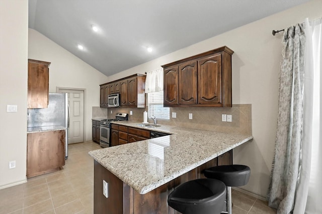 10200 Wildfowl Dr, Fort Worth, TX 76177 - kitchen with stainless steel appliances, light tile patterned floors, a kitchen bar, tasteful backsplash, and lofted ceiling