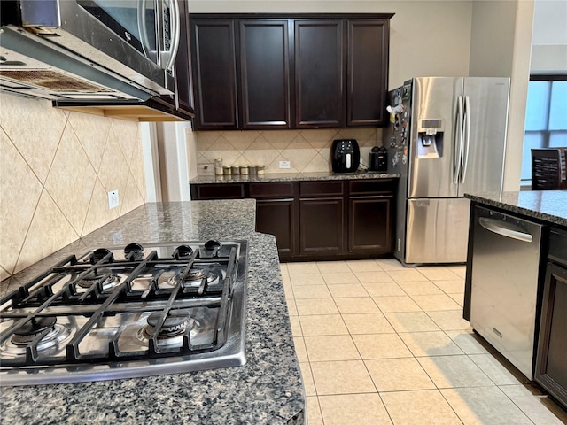 12713 Travers Trl, Fort Worth, TX 76244 - kitchen with appliances with stainless steel finishes, decorative backsplash, dark stone counters, and dark brown cabinets