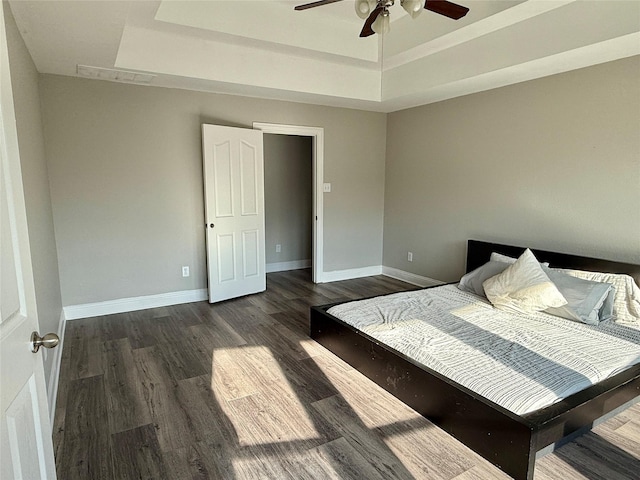 12713 Travers Trl, Fort Worth, TX 76244 - bedroom with a tray ceiling, dark wood-style flooring, and a ceiling fan