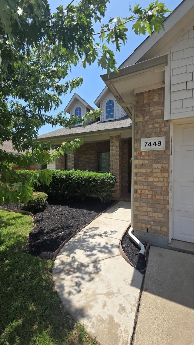 7448 Maroon Dr, Fort Worth, TX 76120 - property entrance featuring brick siding and a garage