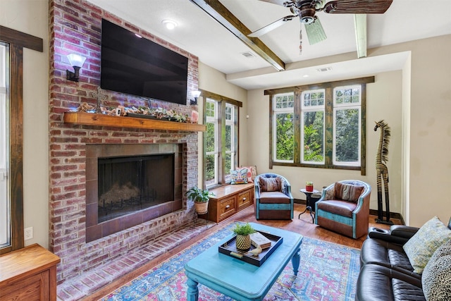 421 Dallas St, Argyle, TX 76226 - living room featuring beamed ceiling, a brick fireplace, wood finished floors, healthy amount of natural light, and a ceiling fan
