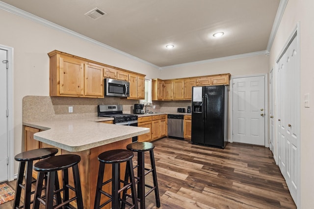 105 William St, Pottsboro, TX 75076 - kitchen with appliances with stainless steel finishes, ornamental molding, light countertops, a peninsula, and decorative backsplash