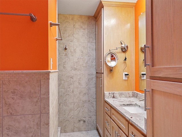 1102 N Graves St, Mckinney, TX 75069 - bathroom featuring vanity, a tile shower, and tile walls