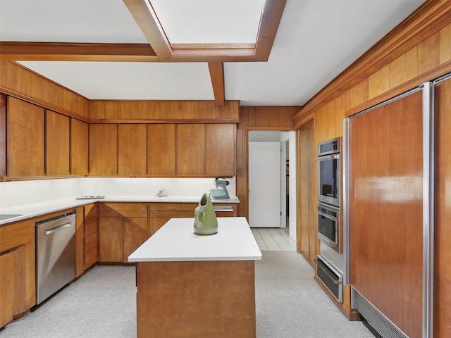 1102 N Graves St, Mckinney, TX 75069 - kitchen featuring stainless steel appliances, a warming drawer, brown cabinetry, light countertops, and beamed ceiling