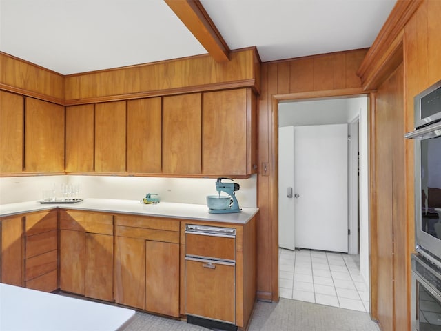 1102 N Graves St, Mckinney, TX 75069 - kitchen with light countertops, brown cabinetry, light tile patterned floors, and wooden walls