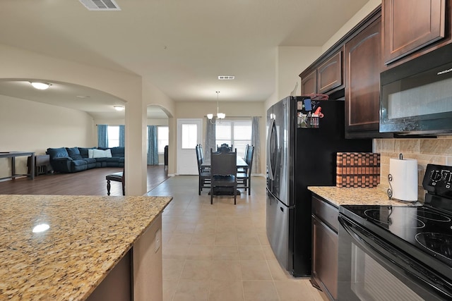 127 Pasture Ln, Decatur, TX 76234 - kitchen featuring black appliances, arched walkways, a chandelier, tasteful backsplash, and light stone counters