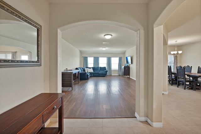 127 Pasture Ln, Decatur, TX 76234 - hall featuring a chandelier, arched walkways, and tile patterned flooring