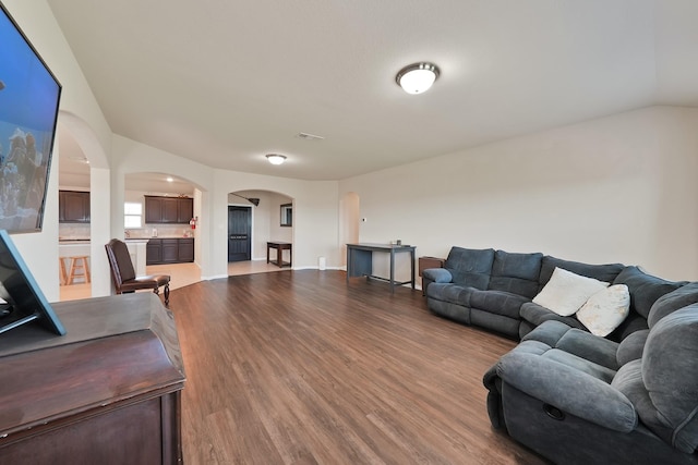 127 Pasture Ln, Decatur, TX 76234 - living area featuring arched walkways, wood finished floors, and vaulted ceiling