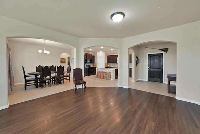 127 Pasture Ln, Decatur, TX 76234 - living area featuring wood finished floors, a chandelier, and arched walkways