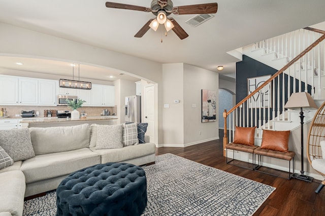 2209 Willard Dr, Mckinney, TX 75072 - living area featuring dark wood-type flooring, a ceiling fan, arched walkways, stairway, and recessed lighting