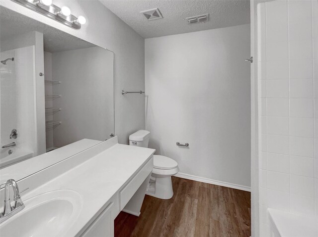 2428 Marimont Ln, Lancaster, TX 75134 - bathroom featuring wood finished floors, bathtub / shower combination, vanity, and a textured ceiling