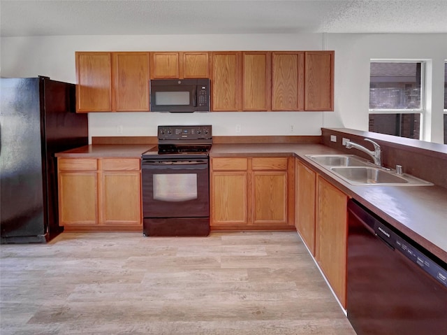 2428 Marimont Ln, Lancaster, TX 75134 - kitchen with black appliances, light wood-style floors, brown cabinets, and a textured ceiling