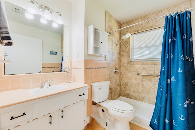 2315 Cardinal Ln, Garland, TX 75042 - bathroom with vanity, a tile shower, tile walls, and tile patterned flooring