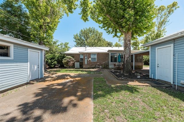 2315 Cardinal Ln, Garland, TX 75042 - back of house featuring an outbuilding, brick siding, and a yard
