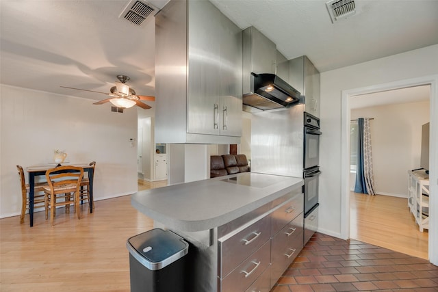 2315 Cardinal Ln, Garland, TX 75042 - kitchen featuring a ceiling fan, cooktop, light countertops, exhaust hood, and light wood-style floors