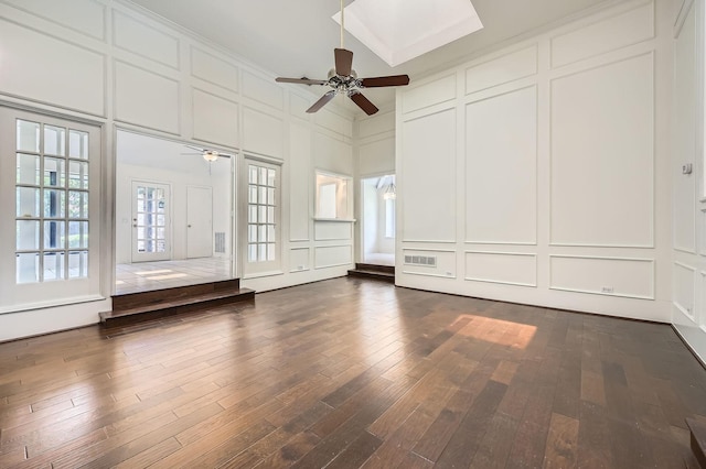 6226 Liberty Hl, Dallas, TX 75248 - spare room featuring a decorative wall, a ceiling fan, dark wood-type flooring, and a skylight