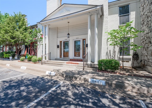 5907 Copperwood Ln Unit 1138, Dallas, TX 75248 - entrance to property featuring brick siding, uncovered parking, a chimney, and a porch
