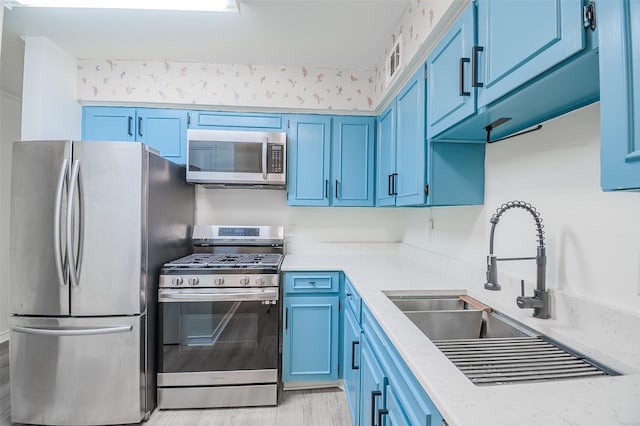 5907 Copperwood Ln Unit 1138, Dallas, TX 75248 - kitchen featuring appliances with stainless steel finishes, blue cabinetry, light stone countertops, and light wood finished floors