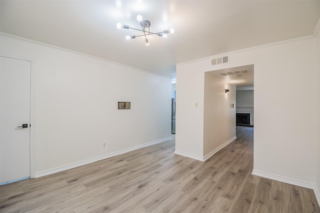 5907 Copperwood Ln Unit 1138, Dallas, TX 75248 - unfurnished room featuring a chandelier, light wood finished floors, ornamental molding, and a fireplace