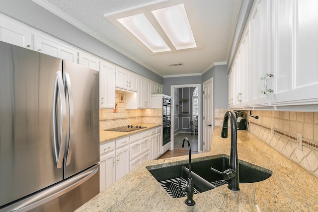 6215 Suffolk Dr, Arlington, TX 76001 - kitchen featuring black appliances, white cabinetry, crown molding, tasteful backsplash, and light stone countertops