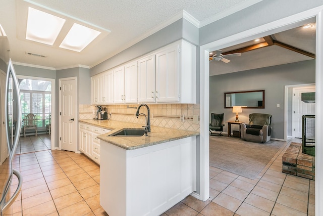 6215 Suffolk Dr, Arlington, TX 76001 - kitchen with light tile patterned floors, stainless steel fridge, white cabinetry, light stone countertops, and backsplash