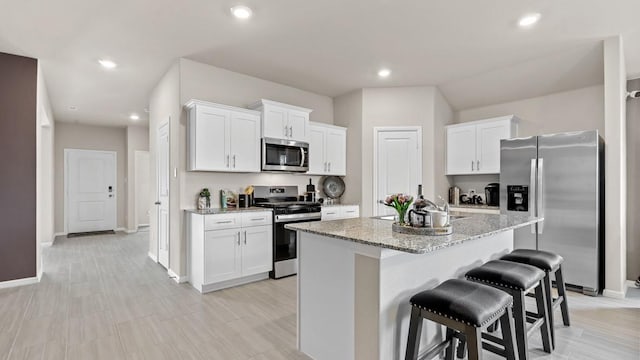9453 Mint Hill Dr, Fort Worth, TX 76108 - kitchen with stainless steel appliances, white cabinets, light stone counters, a kitchen bar, and recessed lighting