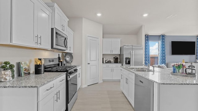 9453 Mint Hill Dr, Fort Worth, TX 76108 - kitchen with appliances with stainless steel finishes, white cabinets, an island with sink, light stone countertops, and recessed lighting