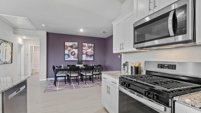 9453 Mint Hill Dr, Fort Worth, TX 76108 - kitchen featuring appliances with stainless steel finishes, white cabinets, light stone countertops, recessed lighting, and light wood finished floors