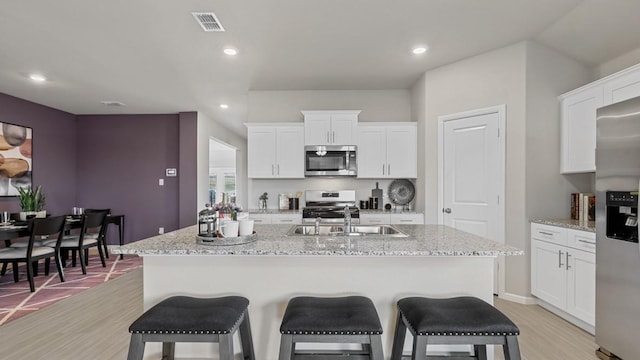 9453 Mint Hill Dr, Fort Worth, TX 76108 - kitchen with stainless steel appliances, a kitchen breakfast bar, light wood-style flooring, an island with sink, and recessed lighting