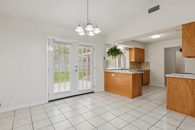 2017 Jessie Pl, Edgecliff Village, TX 76134 - kitchen featuring a peninsula, light countertops, vaulted ceiling, a chandelier, and decorative backsplash
