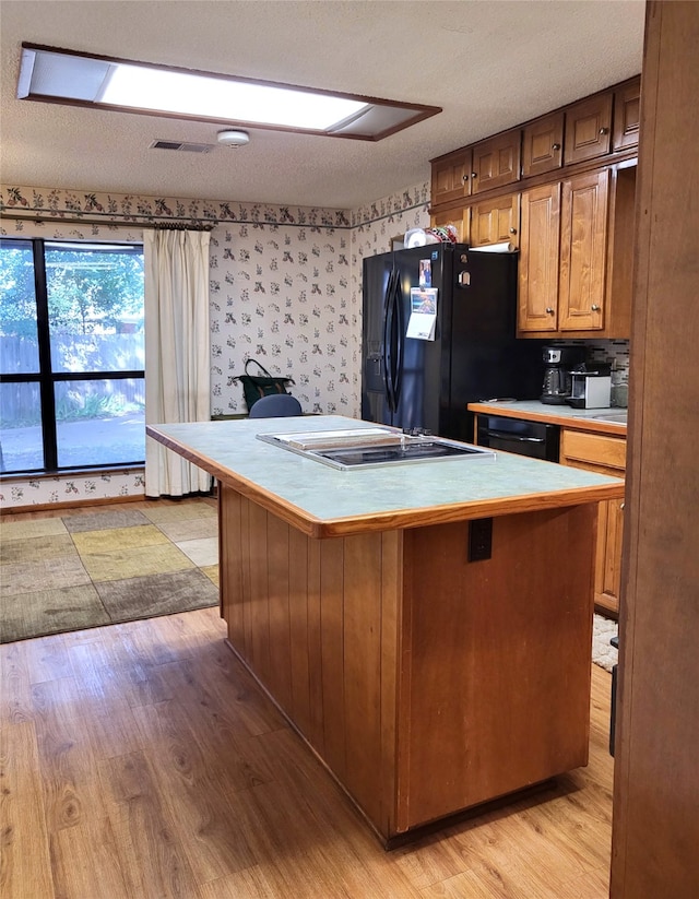 697 Highland Crest Dr, Hurst, TX 76054 - kitchen featuring black appliances, light wood finished floors, a kitchen island, and wallpapered walls
