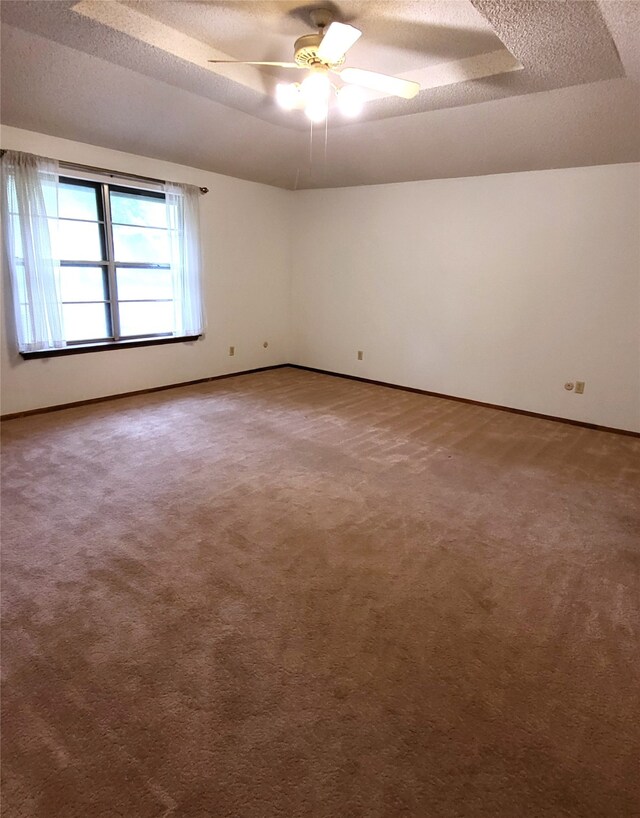 697 Highland Crest Dr, Hurst, TX 76054 - empty room featuring a textured ceiling, carpet, a ceiling fan, and a raised ceiling