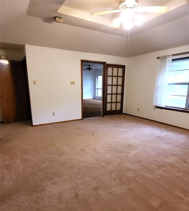 697 Highland Crest Dr, Hurst, TX 76054 - spare room featuring ceiling fan, carpet flooring, a textured ceiling, and a tray ceiling