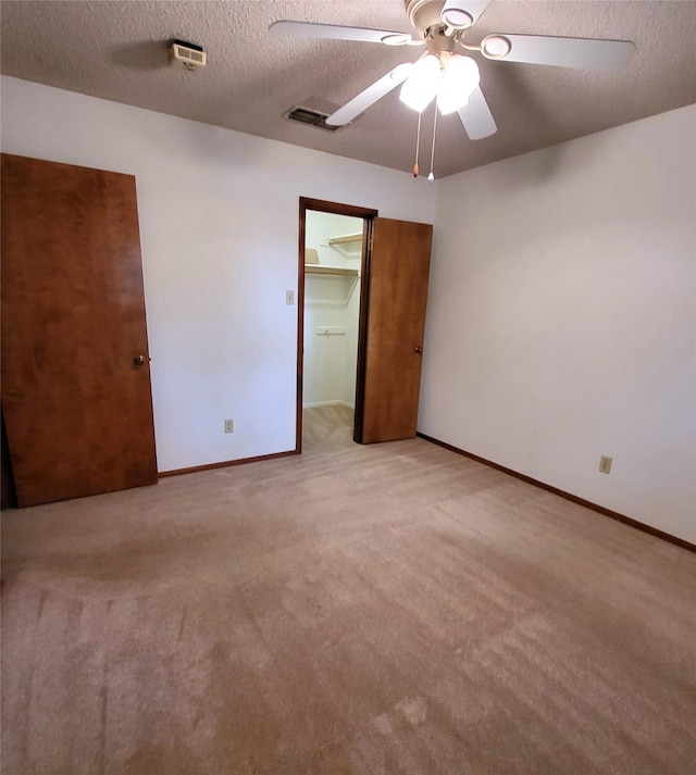 697 Highland Crest Dr, Hurst, TX 76054 - unfurnished bedroom with light colored carpet, a textured ceiling, a walk in closet, a closet, and a ceiling fan